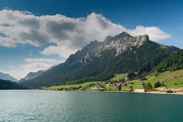 Vista de um idílico e pitoresco lago de montanha turquesa rodeado por floresta verde e picos de montanha nos Alpes Suíços — Fotografia de Stock