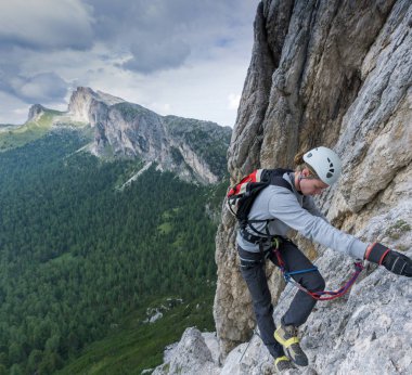 Alta Badia Dolomitleri 'ndeki Via Ferrata' ya yaralı ve kırık ayakkabılarla tırmanan genç bir erkek.