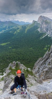 Yirmili yaşlardaki bir kadının dik bir Vi tırmanışının dikey manzarası.