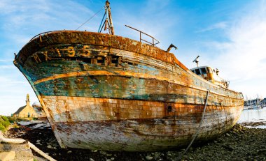 Turistler tarihi kilise ve balıkçı teknesi enkazlarını ziyaret ediyorlar.