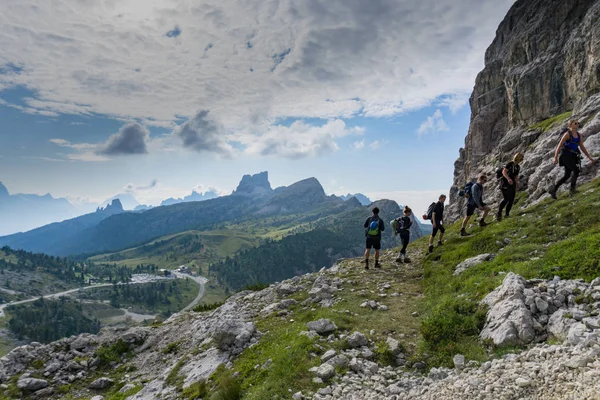 group of mountain climbers hiking up a mountain side to a hard c