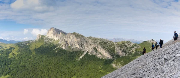 Vista panorâmica de um grupo de alpinistas caminhando até um lado da montanha para uma rota de escalada difícil — Fotografia de Stock