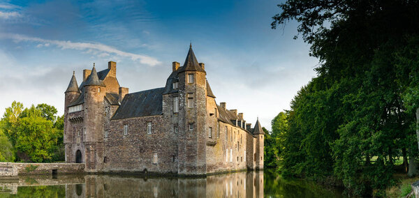 view of the historic Chateau Trecesson castle in the Broceliande Forest with reflections in the pond