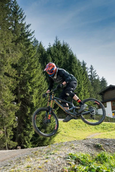 Ciclista de montaña cuesta abajo saltando alto y montando duro en Lenzerheide — Foto de Stock