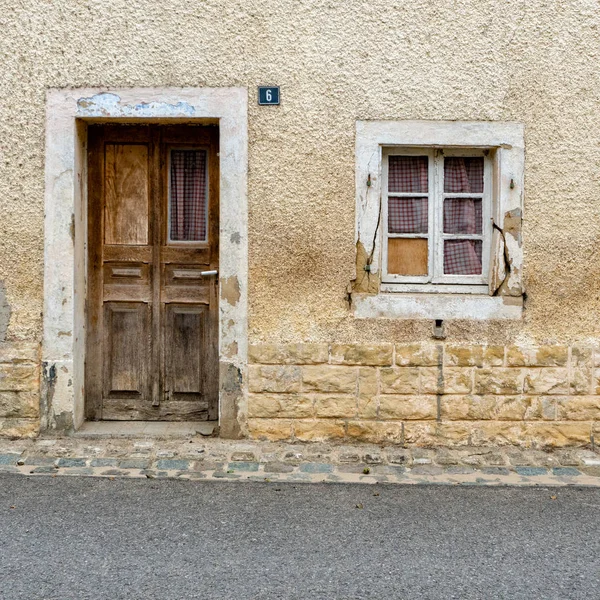 Vista de una casa vieja y abatida con puerta de madera y ventana de cristal — Foto de Stock