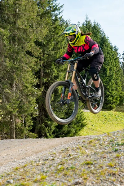 Ciclista de montaña cuesta abajo saltando alto y montando duro en Lenzerheide — Foto de Stock