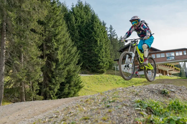 Yokuş aşağı bisikletçi yüksekten atlıyor ve Lenzerheide 'de iyi sürüyor. — Stok fotoğraf