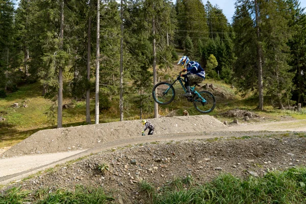 Yokuş aşağı dağ bisikletçisi yüksekten atlıyor ve İsviçre Alplerinde Lenzerheide 'de çok hızlı gidiyor.