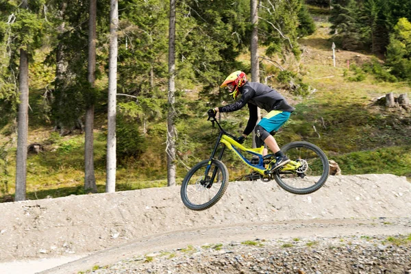 Ciclista de montaña cuesta abajo saltando alto y montando duro en Lenzerheide —  Fotos de Stock