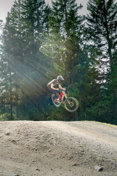 Ciclista de montaña cuesta abajo saltando alto y montando duro en Lenzerheide — Foto de Stock