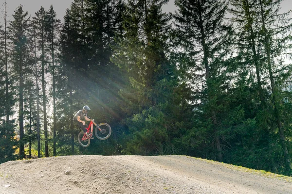 Ciclista de montaña cuesta abajo saltando alto y montando duro en Lenzerheide — Foto de Stock