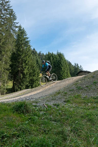 Yokuş aşağı bisikletçi yüksekten atlıyor ve Lenzerheide 'de iyi sürüyor. — Stok fotoğraf