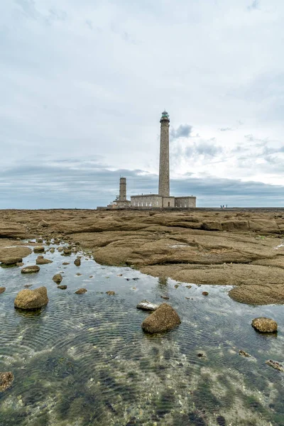 Faro de piedra alto con piscinas de marea rocosas en primer plano — Foto de Stock
