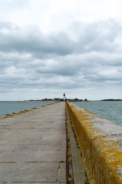 Cais de pedra ong levando ao farol do porto em Saint-Vaast-la-Hogue, na Normandia — Fotografia de Stock