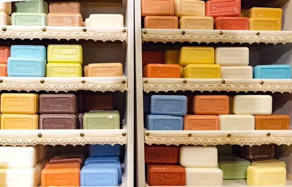 Barras coloridas de sabão empilhadas em um armário de madeira — Fotografia de Stock