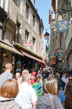 Dar bir sokakta ezilen büyük bir turist kalabalığı.