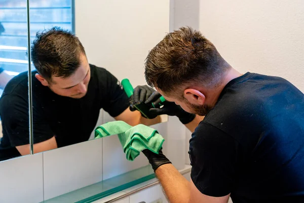 Seorang Petugas Kebersihan Profesional Menggores Kotoran Dan Noda Dari Cermin — Stok Foto