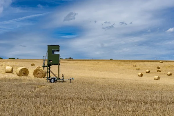 A high seat for hunting trailer parked i na golden wheat field