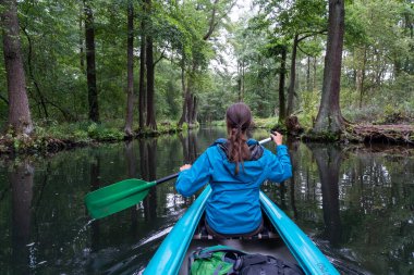 Almanya 'nın Spreewald bölgesindeki kanal ve kanallarda kürek çeken dişi bir kano.
