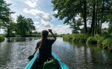 Almanya 'nın Spreewald bölgesindeki kanal ve kanallarda kürek çeken dişi bir kano.