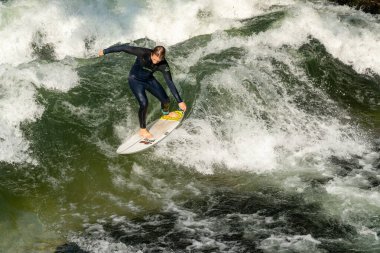 Münih, Bavyera / Almanya - 17 Eylül 2020: Münih şehir merkezindeki Eisbach deresinde sörf yapan adam
