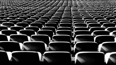 A black and white view of endless rows of empty chairs in a stadium clipart