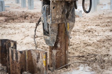Şantiyede istinat duvarı çelik sac kazık sürme makinesi iş. 