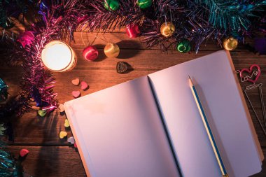 Masada noel dekor ile yanan mum yanında açık günlük / Noel veya yeni yıl festival dekor tasarımı / Üst ten görünüm fotoğraf konsepti.
