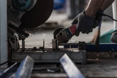 Fabrikada taşlama makinesi tutan işçinin eli