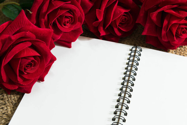 Daily note-book of love and red rose on a wooden background. for valentine day