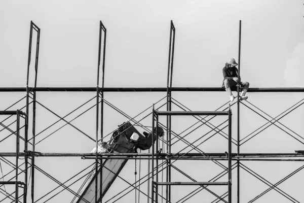 建筑工人在建筑工地的脚手架上施工 不安全或危险 黑白图像 — 图库照片