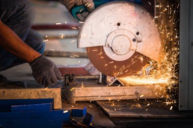 Metali keskin kıvılcımlarla kesen endüstriyel işçiler. Kesme makinesine odaklan.