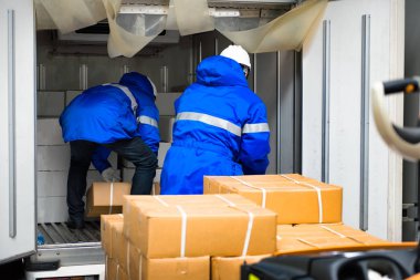 Depodan müşteriye ihraç edilecek mallar için kapıkapılarında teslim alma ile taşıma için paket kutularla çalışan el işçisi