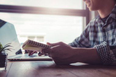 Mutlu işadamı günlük günlük ve avantajları internet teknolojisi kullanarak iş yaparken ev ofisinde geliştirilmiş performans ile sonuçlanan. Günlük planlayıcı kitabına odaklanın.