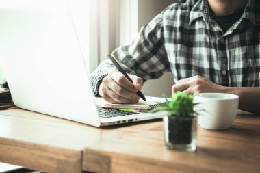 Kafede Asyalı genç bir adam. Nasıl serbest tasarım düşünme işleri yaşam tarzı. Genç Asyalı işadamı hafta sonu aktivitesinde kahve ile dinlendiriyor. içme konsepti.