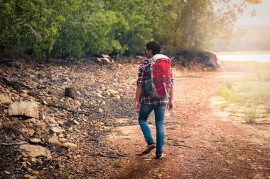 Sırt çantalı bir yürüyüşçü su baskınlarının olduğu yerlerden geçer ya da dağlarda taşların üzerinde yürür. Yürüyüş ve eğlence teması.