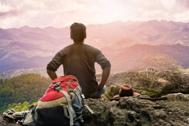 Yürüyüş adam tüm gün yürüyüş ve sırt çantası ile üst tepede otururken manzara manzarası ile rahatlatıcı meditasyon keyfini sonra sakin dağlar manzarası ile üst tepede oturan rahatlayın.
