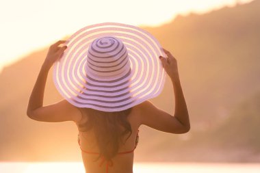 Sahilde gün batımına bakan bir kadın. tatil canlılığı sağlıklı yaşam konsepti