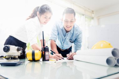 Modern ofiste Asyalı çiftler birlikte Mimari İç planı tarama ve iş Inşaat İlerleme hakkında Tartışma tarama zaman zevk