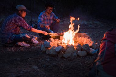 Mutlu arkadaşlar geceleri doğada şenlik ateşinin tadını çıkarırken kamp yapıyor, kampta parti yapıyor, yaz tatilinde kutlayan Asyalı gençler, yaz tatili ve seyahat aktivitesi. Şenlik ateşine seçim odağı.