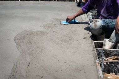 Sıva beton çimento iş. Mason yerleri yerle bir ediyor. Bina inşaatının düzgün veya tesviye beton levha zemin iş adımı için plastik kare mala kullanma.