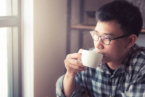 Asian young man drinking coffee in the cafe., How to lifestyle of young asian businessman in the weekend activity relaxing with the coffee. drinking concept.