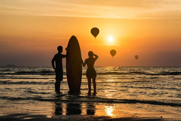 Silhouette Szörfös Férfi Húga Állva Boldogan Élvezni Strandon Akik Hőlégballon — Stock Fotó