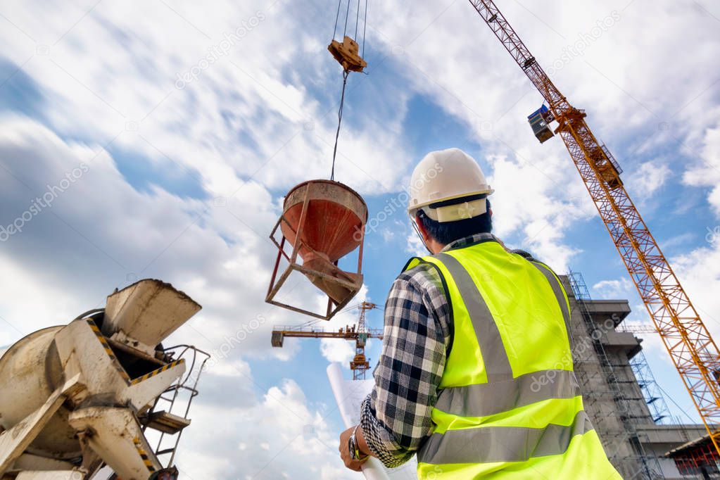 Engineering Consulting people on construction site holding blueprint in his hand. Concrete casting in construction site and control workflow of new building.