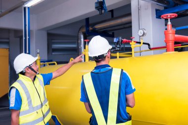 Fabrika işyerinde makine dairesinde üretim süreci için eğitim veren mühendisler. Seçim odak insanlar öğrenme.