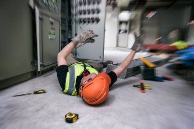 Fabrikanın kontrol odasında elektrikçi veya bakım işçisinin işyerinde kaza. Duygular için yakınlaştırma filtresi efekti ekleme.