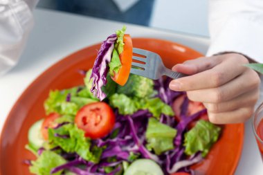 Sebze salatası kasede ve çatal elinde. Sağlıklı beslenme kavramı.