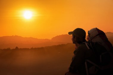 Genç Kadın Sırt Çantası siluetoturma ve dağ tepede gün batımı zamanı arıyor. Backpacker yaz konseptinde.