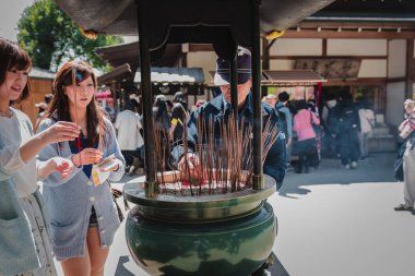 Tokyo, Japonya - Mar 2015: Turistler bu arada Tütsü brülör içine tütsü işlemeli Japon Intendant Kyoto Kinkaku-ji Tapınağı'nda tütsü brülör joss çubukları kurtulmak