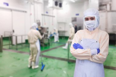 Maskeli ve eldivenli beyaz koruyucu üniforma. Gıda endüstrisinde kalite kontrol işçisi, gıda fabrikasının zeminini temizleme, genç bayan yönetici..
